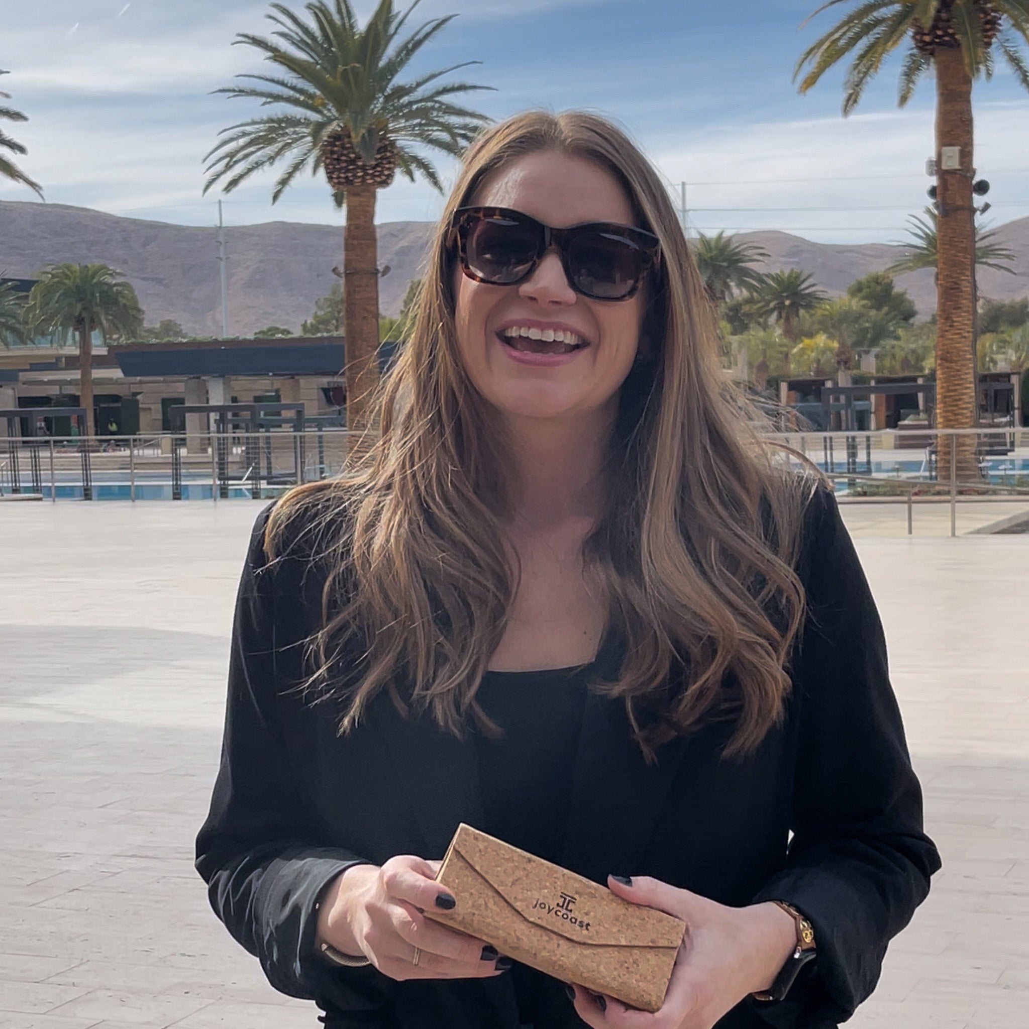Woman wearing oversized tortoise sunglasses with dark lenses