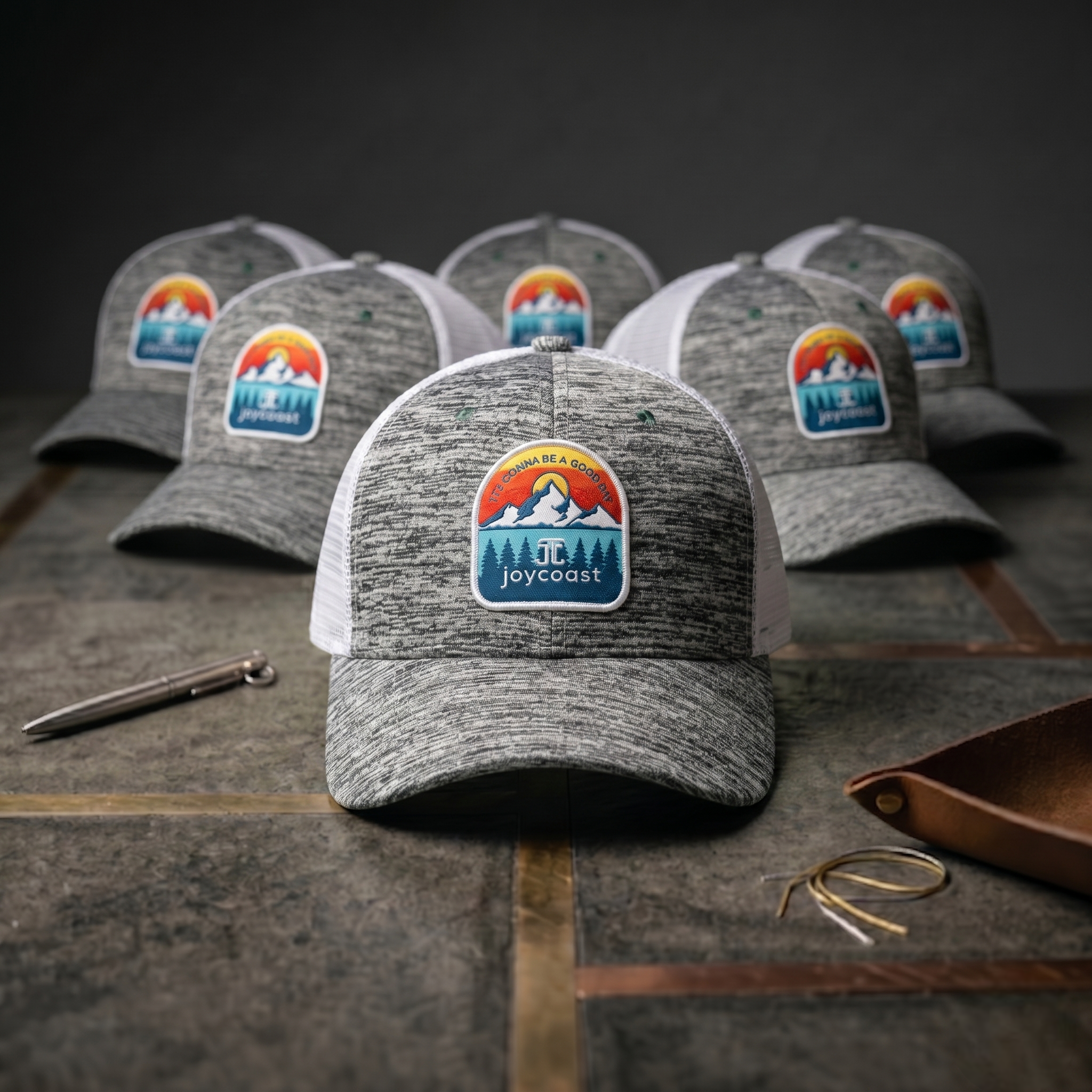 Set of heather gray baseball caps with white mesh backs and Joycoast logo patches