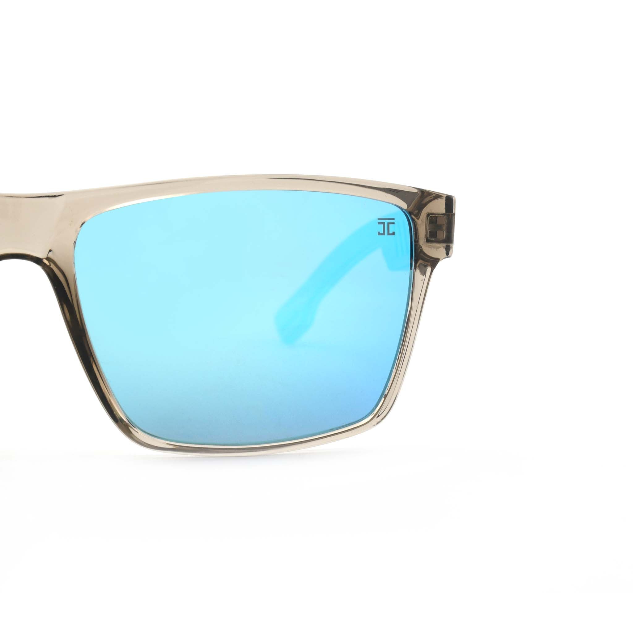 Partial view of Joycoast Apex transparent frame sunglasses showing a blue reflective lens and the "Joycoast" logo.
