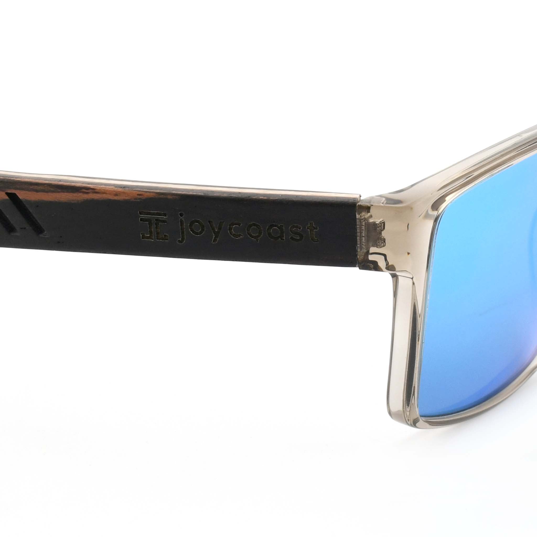 Close-up of a wooden sunglasses arm with the "Joycoast" logo and slogan "It's gonna be a good day." engraved.