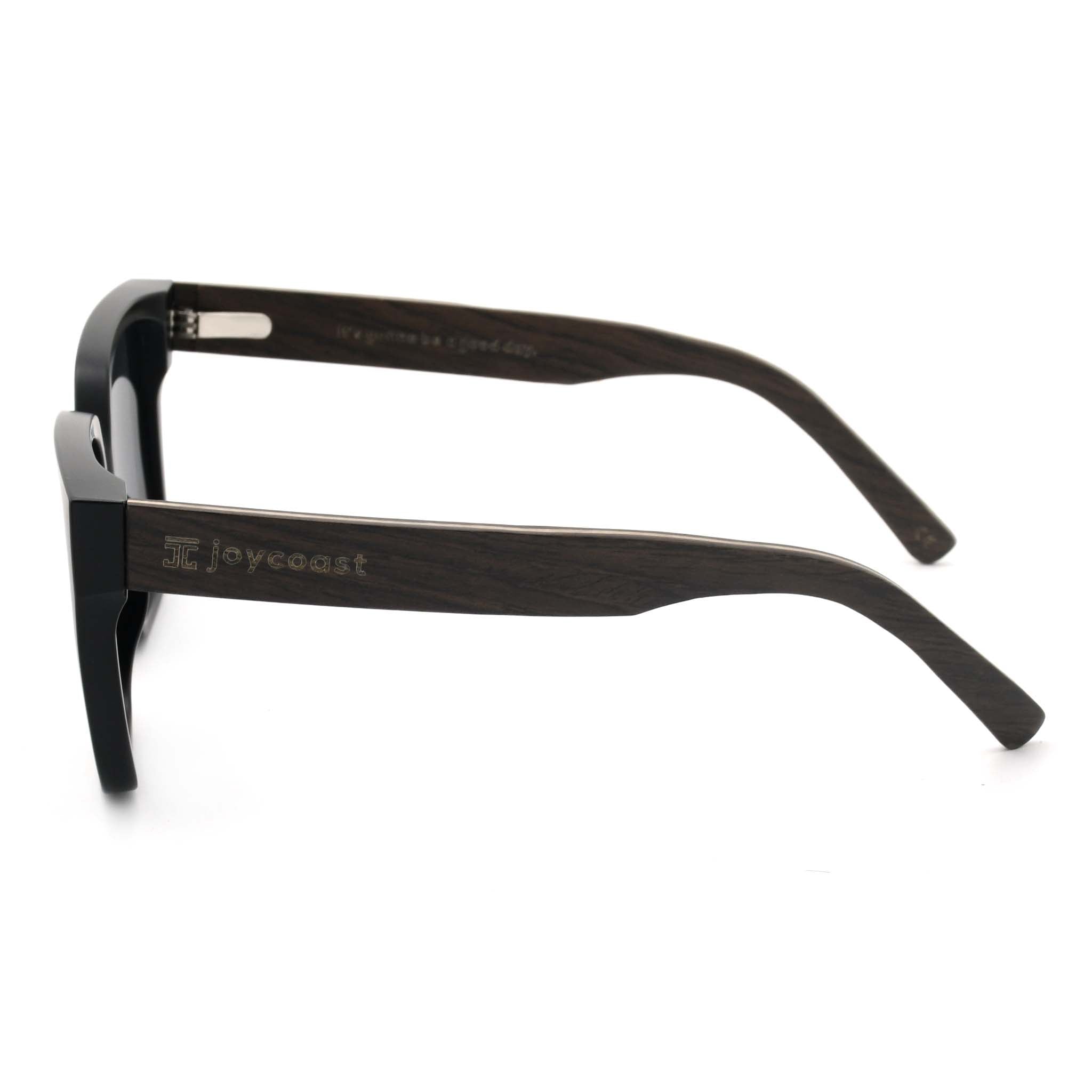 Joycoast black sunglasses with dark wooden arms and an engraved "Joycoast" logo, viewed from the top down on a white background.