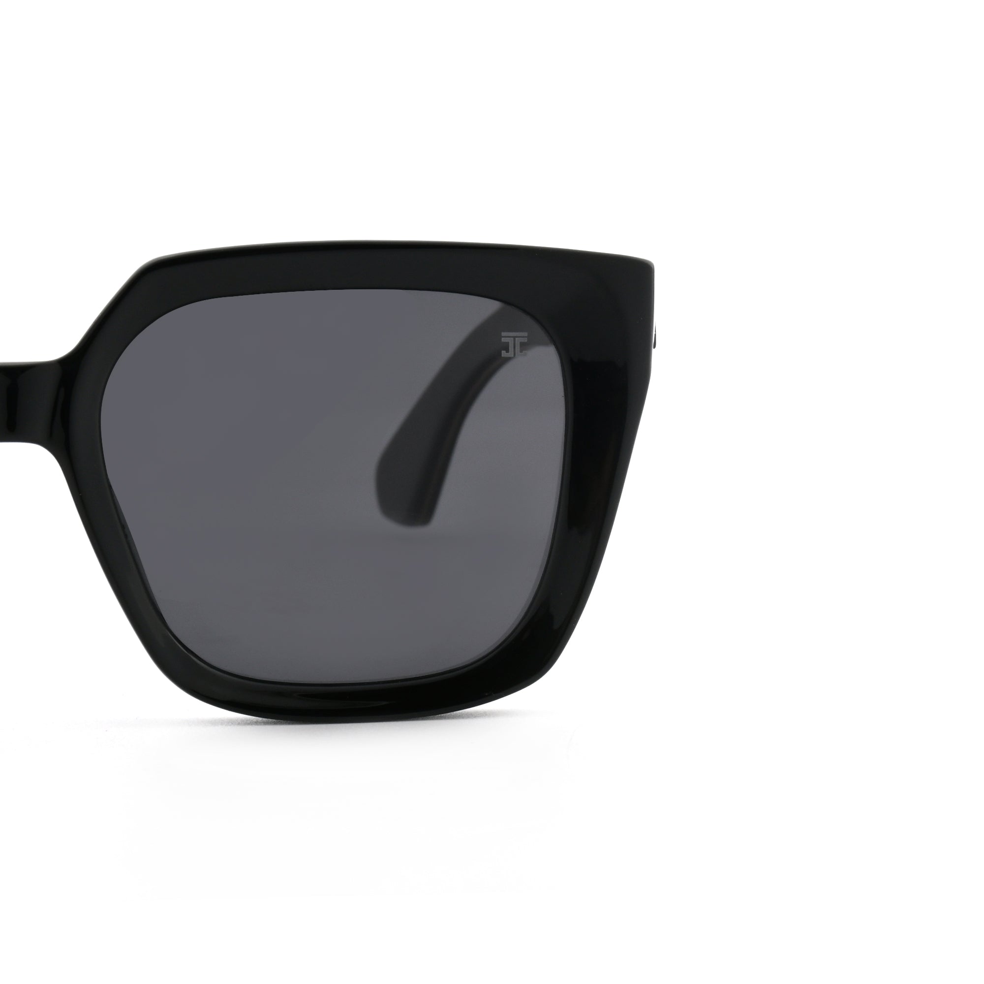 Partial view of black wooden square sunglasses showing the frame and dark lens.