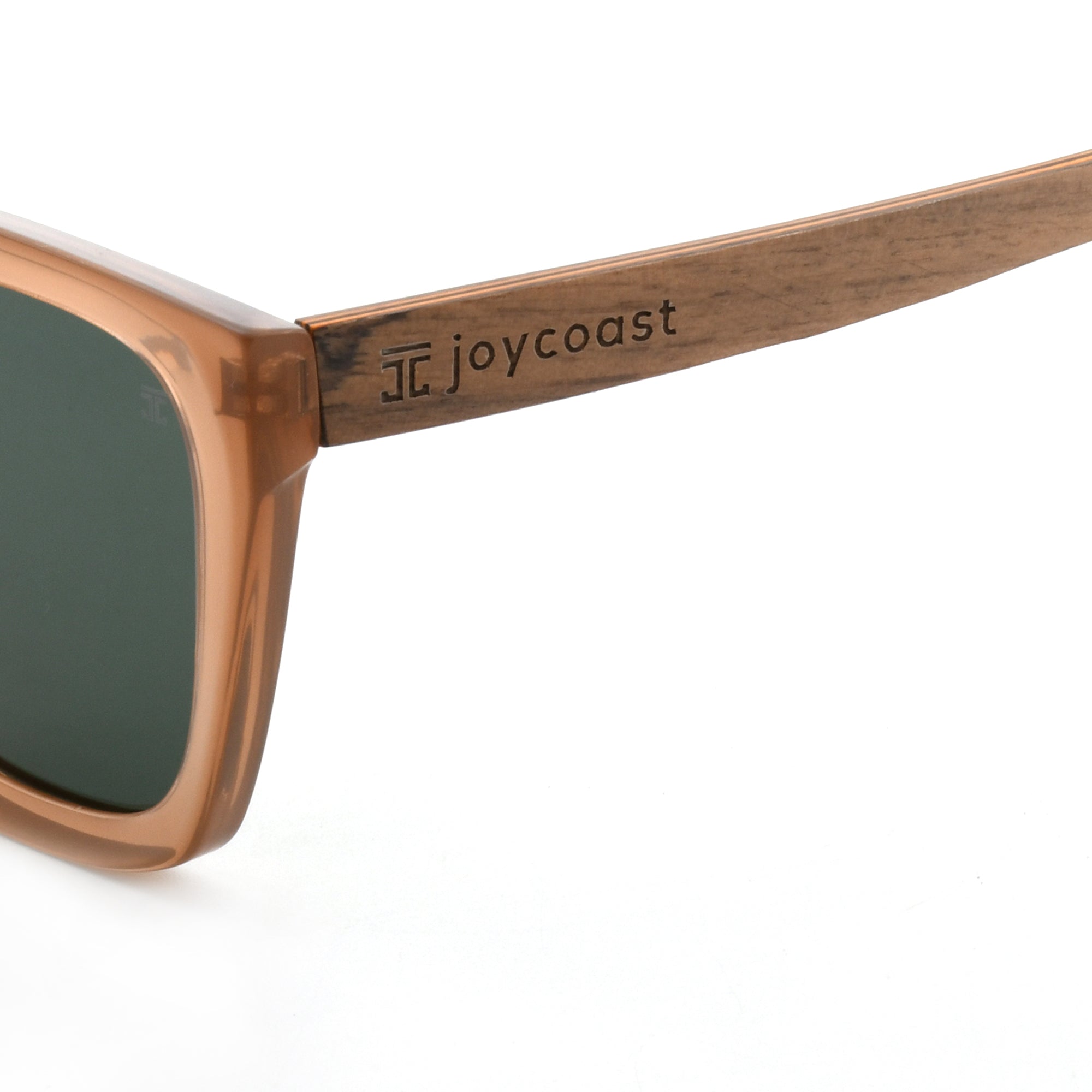 Close-up of brown wooden sunglasses arm with "Joycoast" logo engraved.