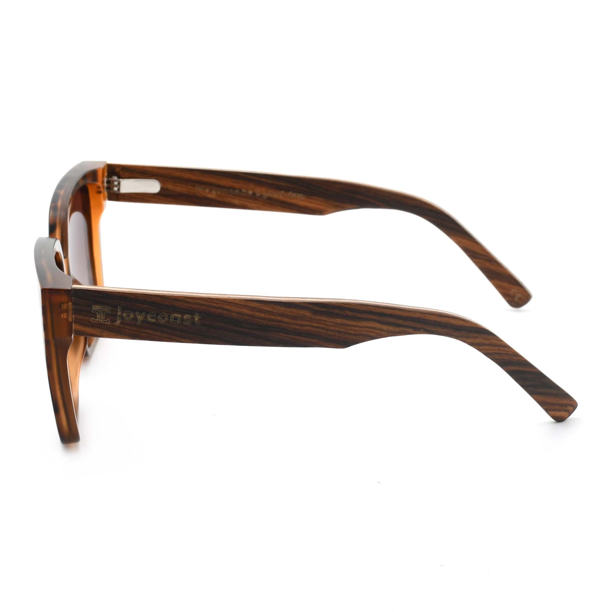 Joycoast tortoise shell sunglasses with wooden arms and an engraved "Joycoast" logo, viewed from the top down on a white background.