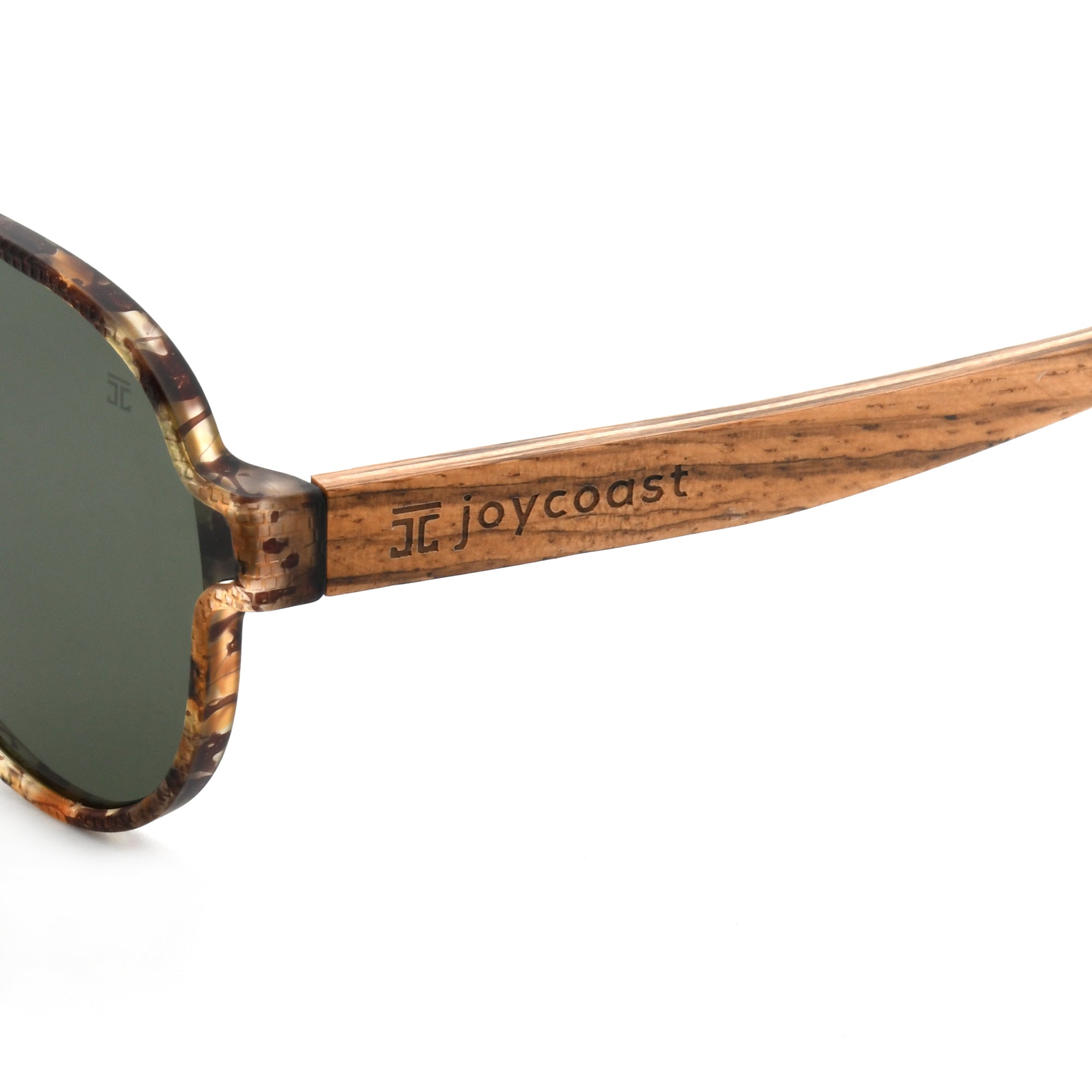 Close-up of Joycoast tortoise shell wooden aviator sunglasses arm with "Joycoast" logo engraved near the dark green lens.
