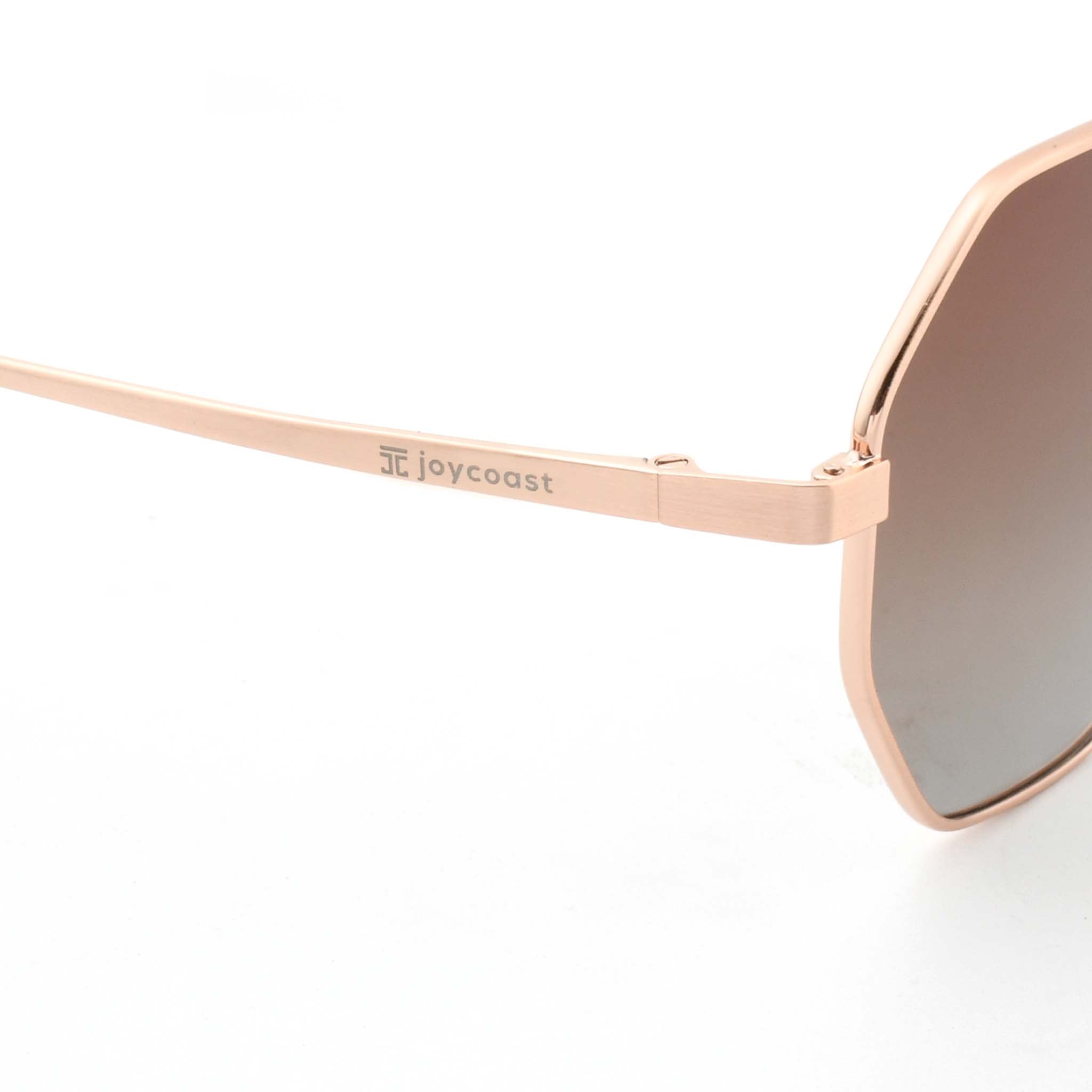 Close-up of the rose gold metal arm of Joycoast Vesuvio sunglasses, with "Joycoast" engraved and a brown gradient lens visible.