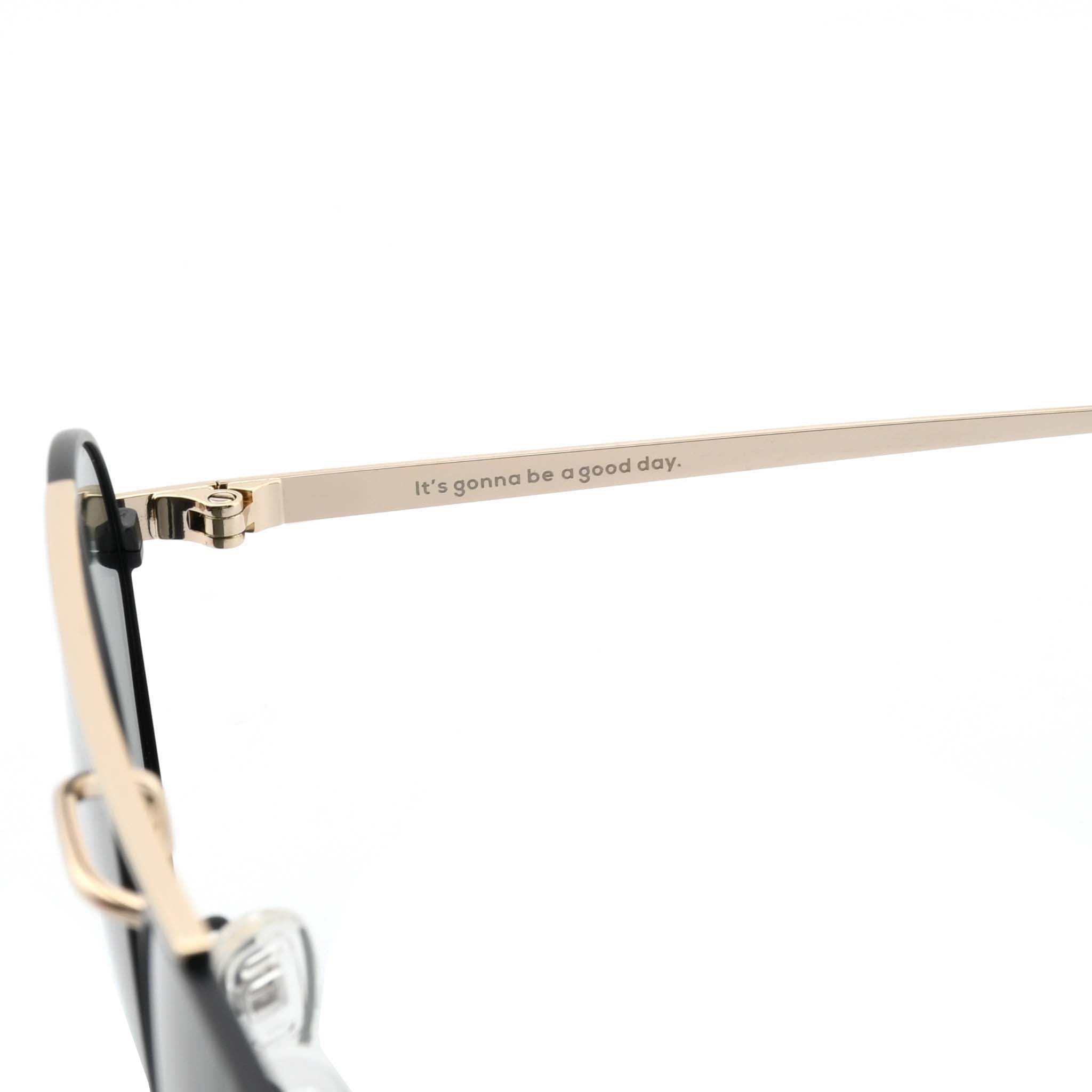 Close-up of the gold metal arm of Joycoast Willow sunglasses with the slogan, "It's gonna be a good day." engraved.