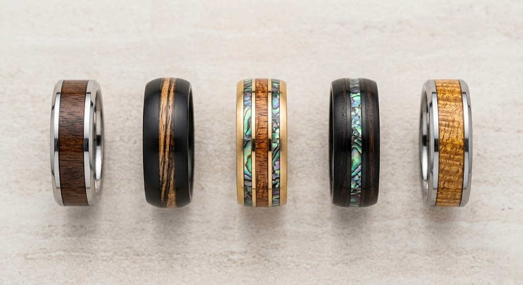 Four distinct wooden rings displayed, each featuring unique designs and textures, showcasing craftsmanship and variety.