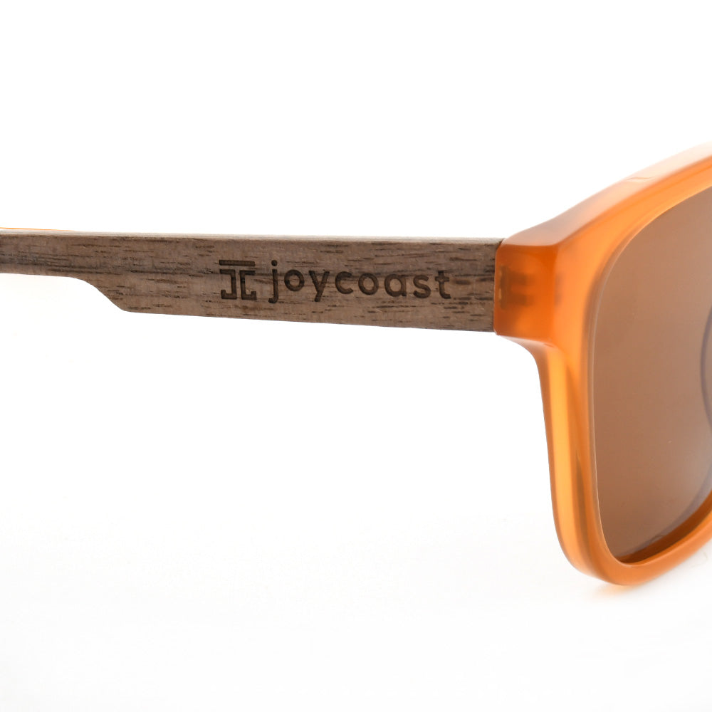Orange sunglasses with wooden temple arm detail and brown lens edge