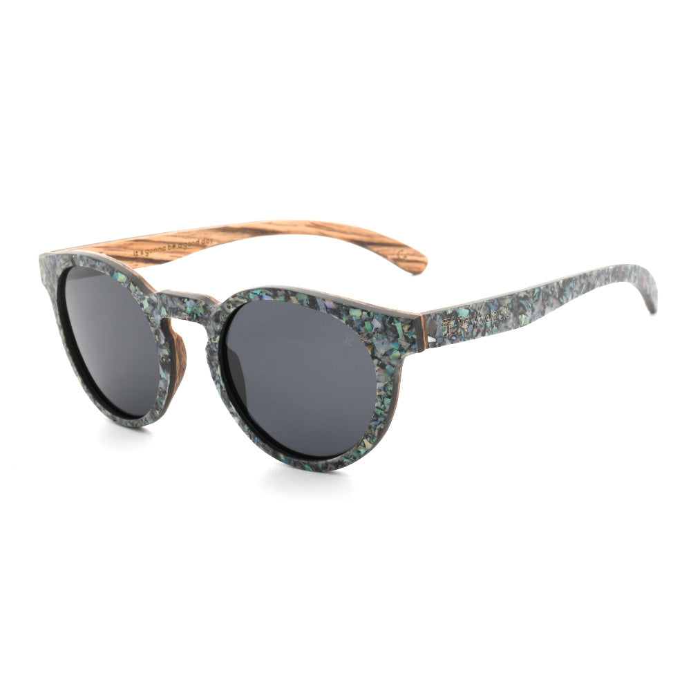 Round sunglasses with abalone-pattern frame, dark gray lenses, curved brown arms.