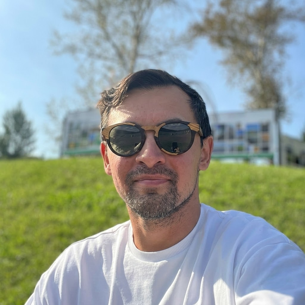 Round dark wooden sunglasses with grey lenses worn on a man’s face