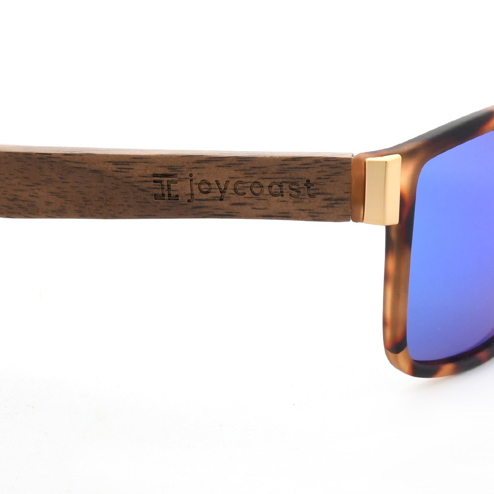 Sunglasses with engraved joycoast logo on wood temple and blue lens