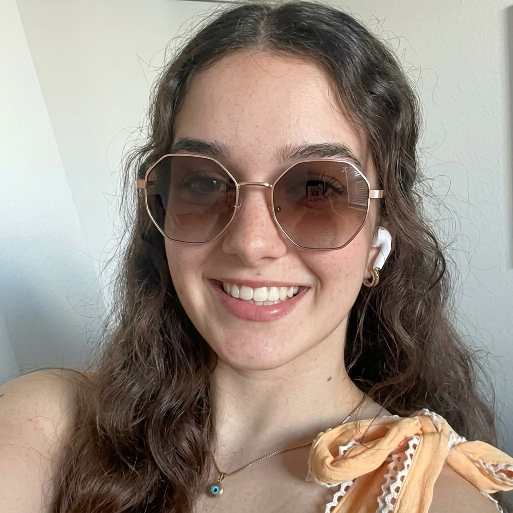 Sunglasses on model with rose-gold metal frame and tinted brown lenses