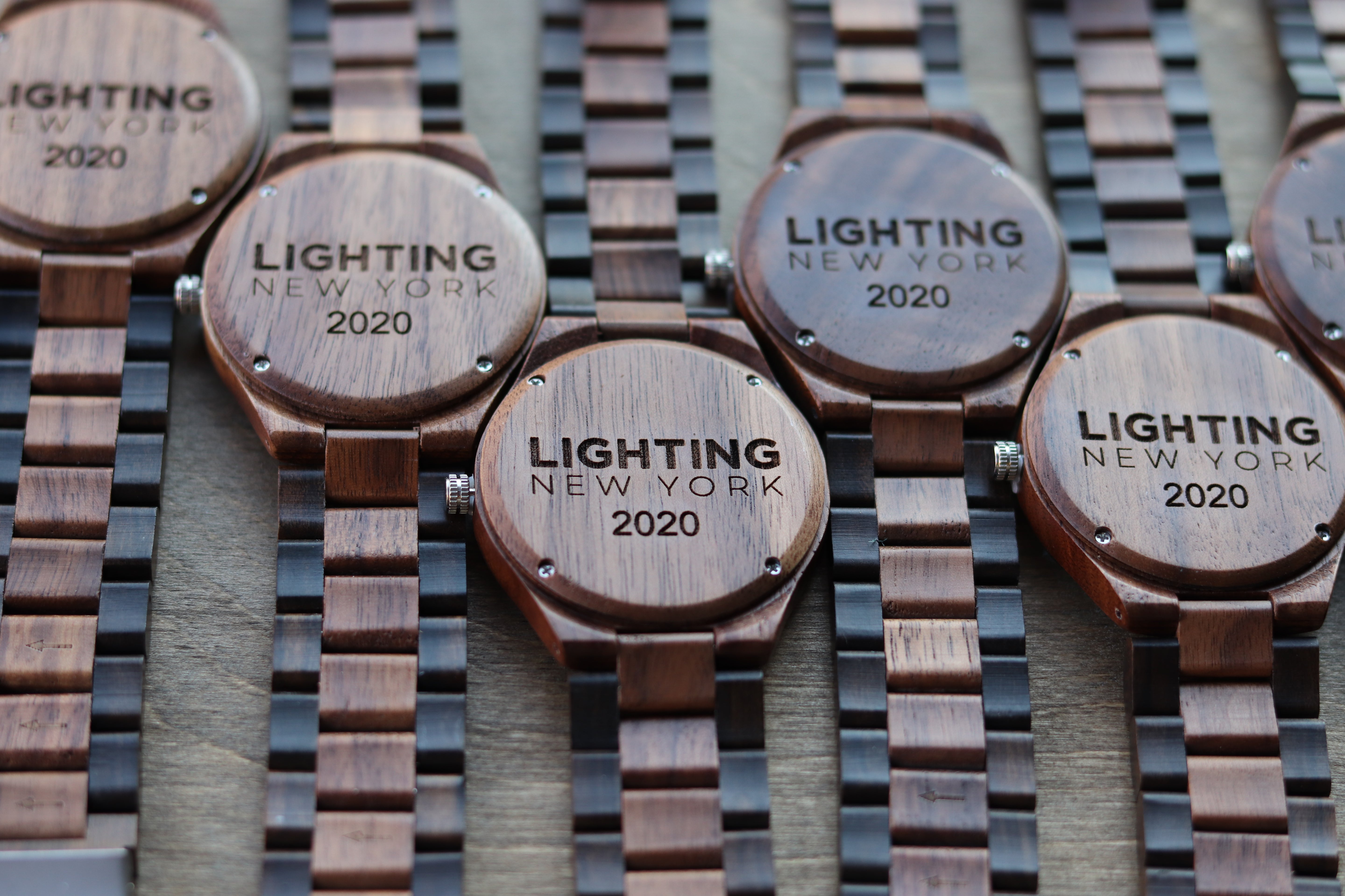 Wooden watches engraved with the phrase "Lighting New York," showcasing a blend of craftsmanship and urban style.