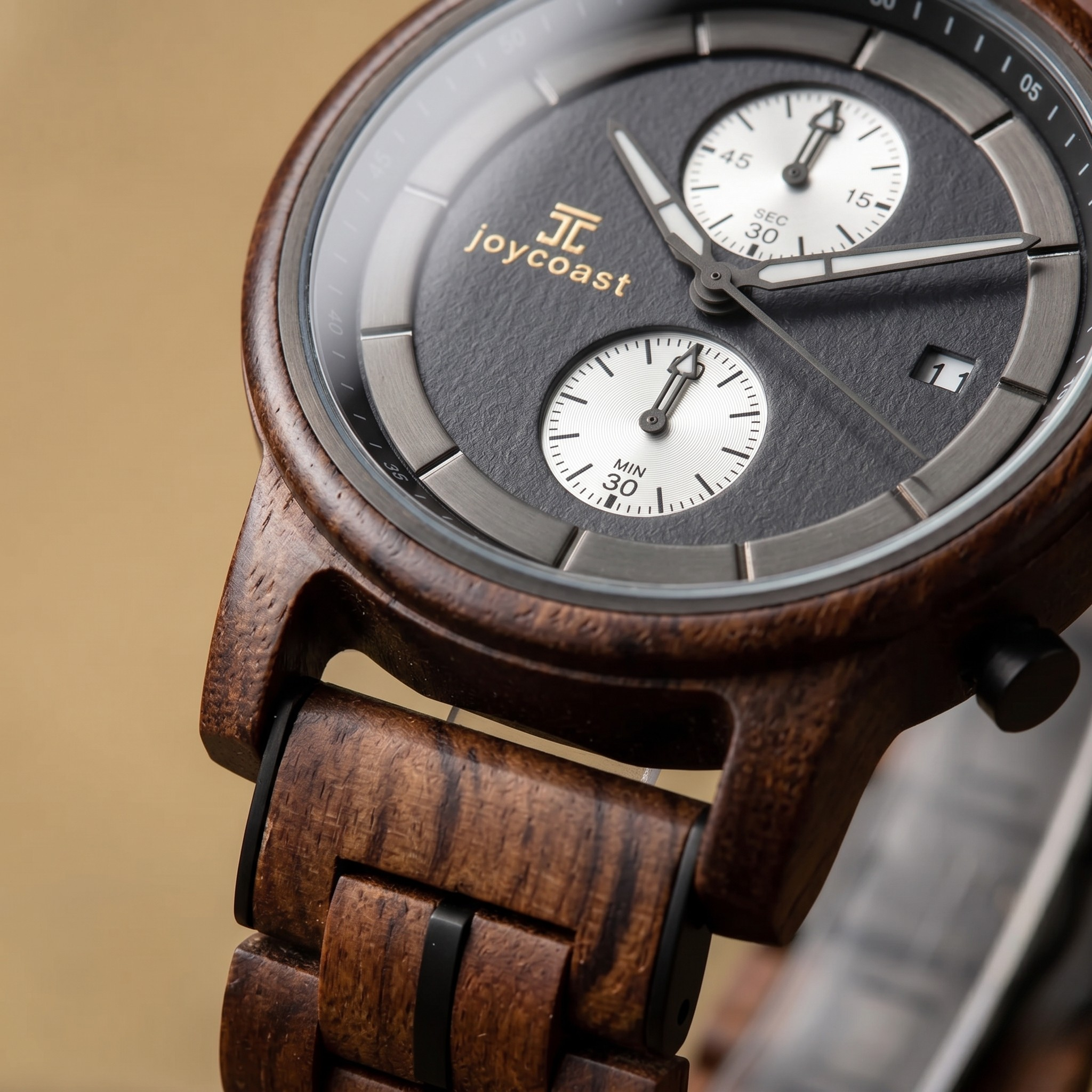 Close-up of walnut wood chronograph watch dial with two subdials