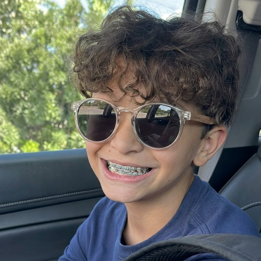 Jiras round kids sunglasses on child with dark lenses and clear light frame