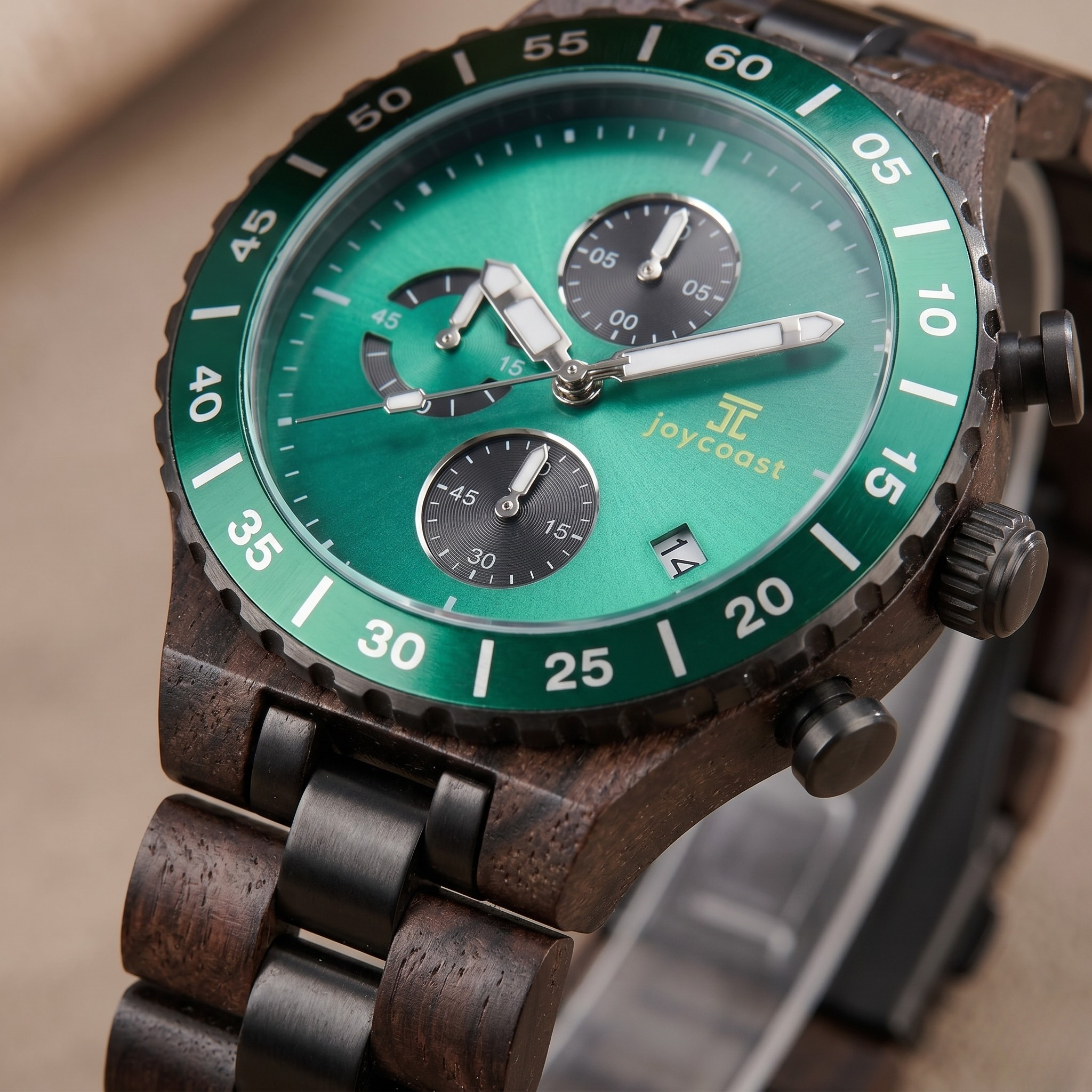 Close-up chronograph watch with green dial, subdials, black and wood case