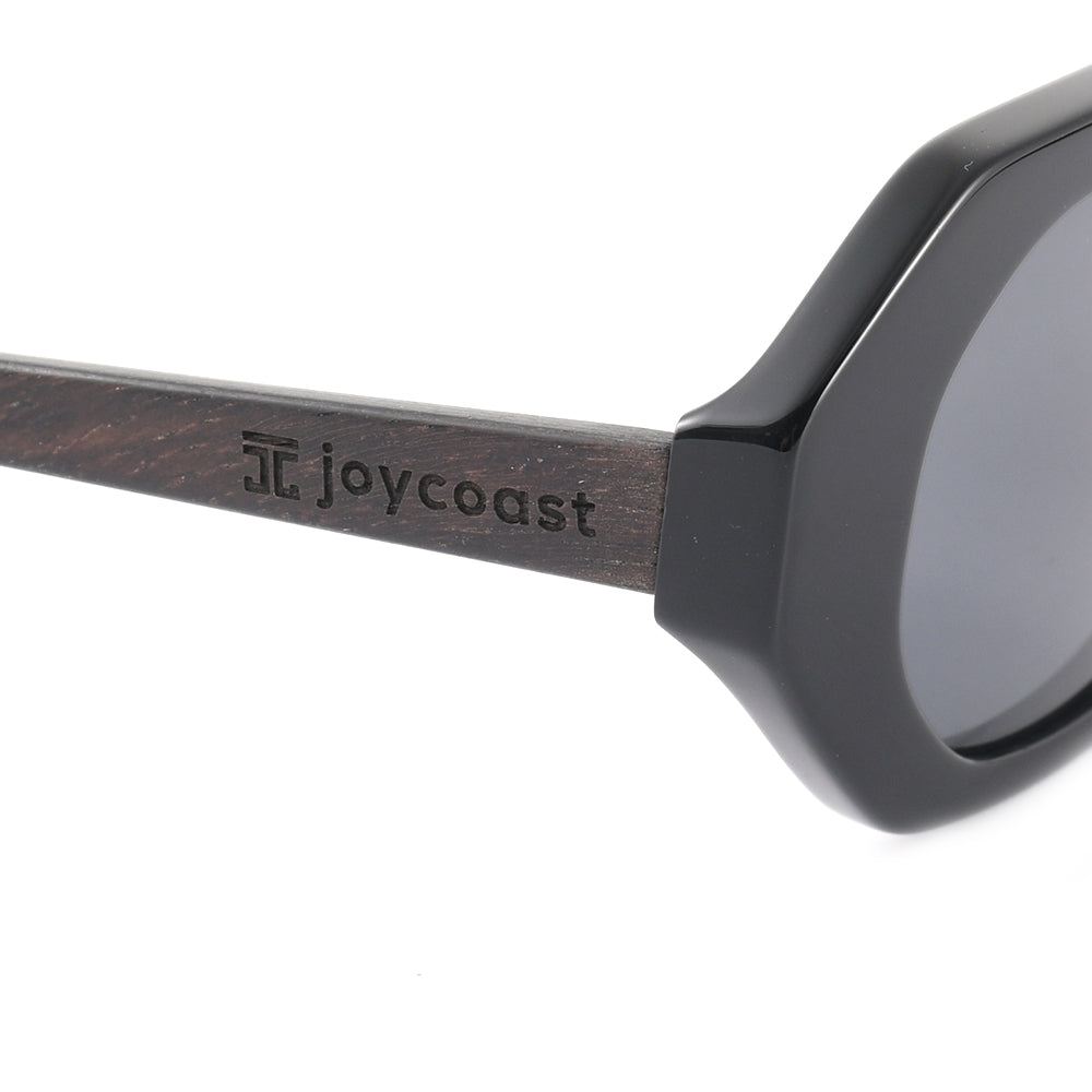 Women's sunglasses side view, black frame with engraved joycoast on wood temple