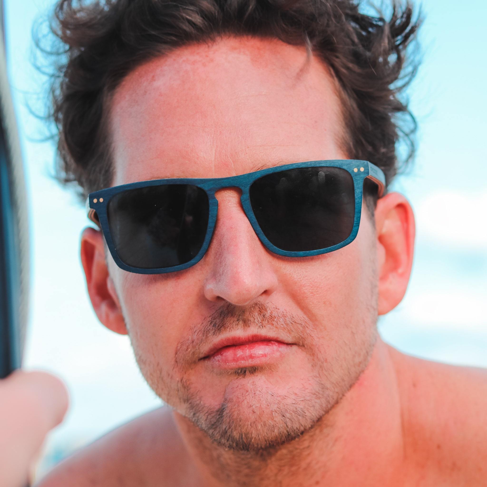 Wayfinder sunglasses with dark rectangular lenses and speckled blue frame
