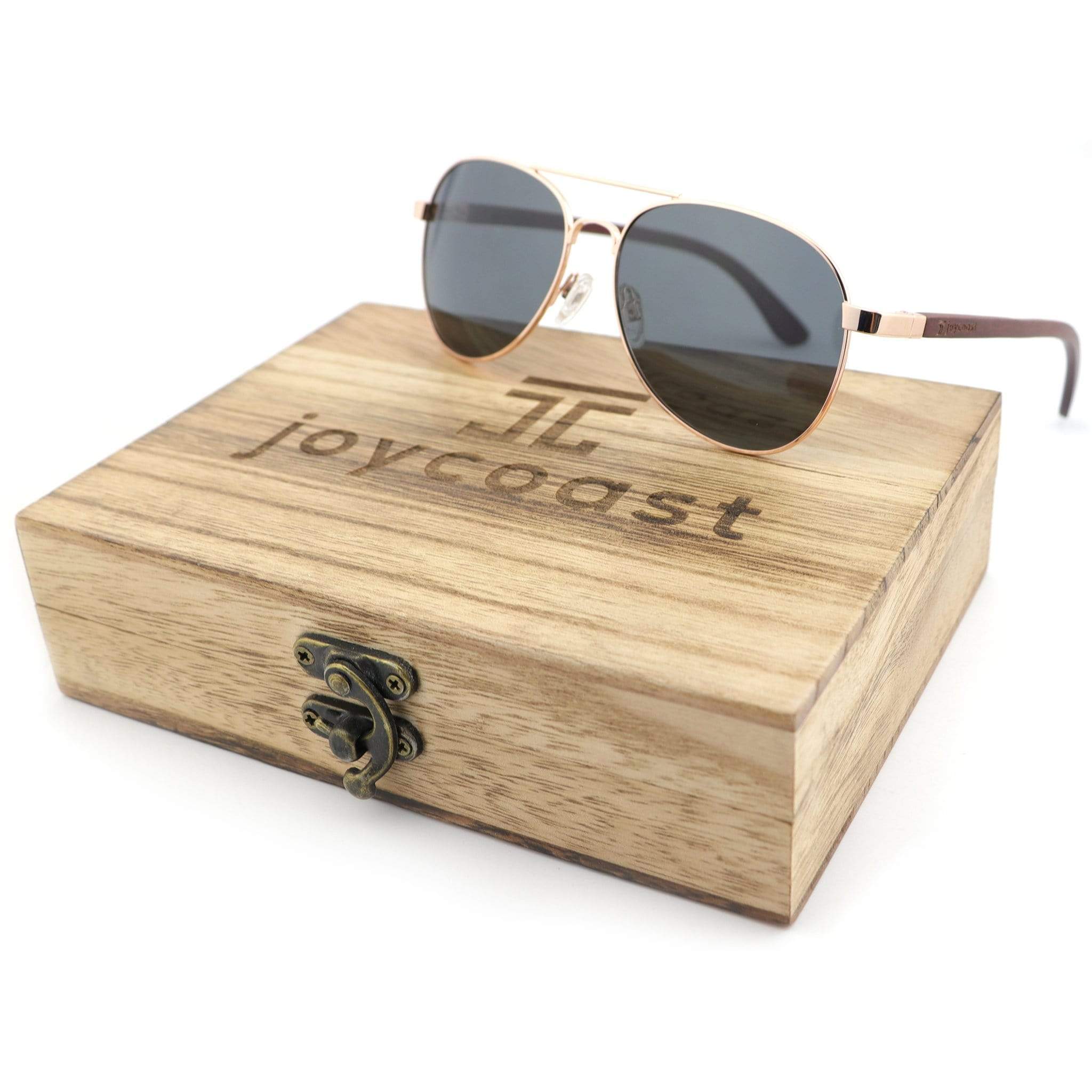 Aviator sunglasses with rose gold frames and dark lenses on a wooden case