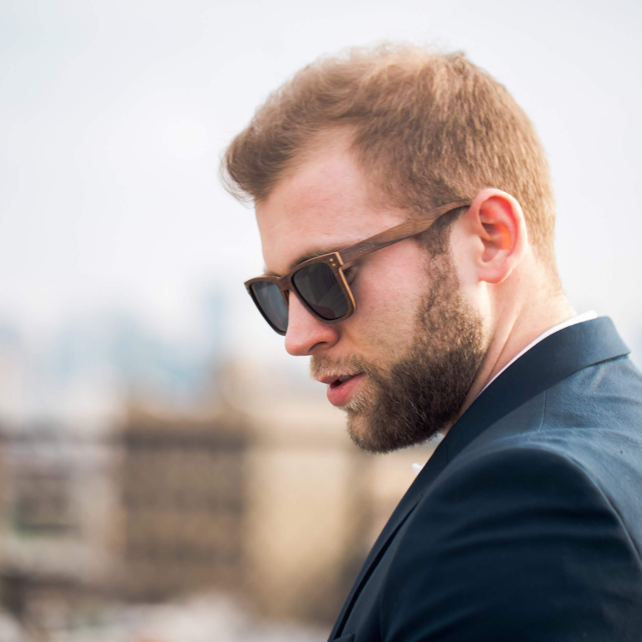 Wood sunglasses on a man, dark square lenses and slim temple arms