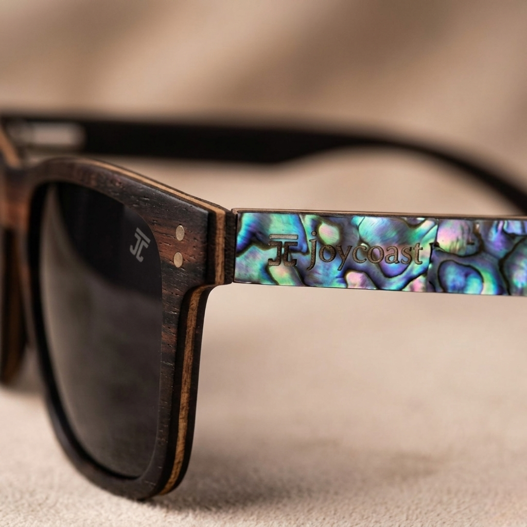 Ebony wood sunglasses temple detail with abalone inlay and 'Tj Joycoast' lettering