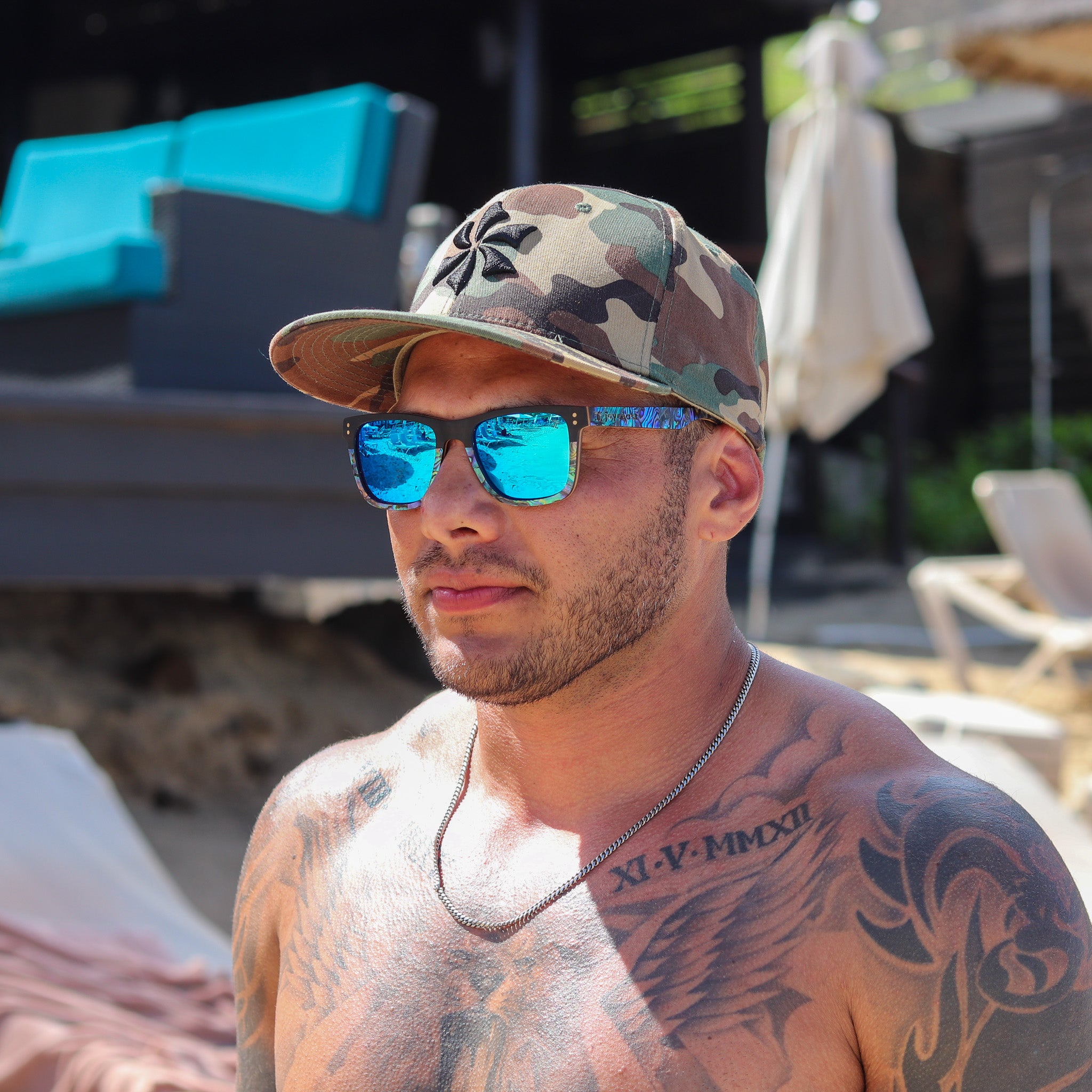 Blue tinted sunglasses with reflective lenses and wooden frame worn outdoors