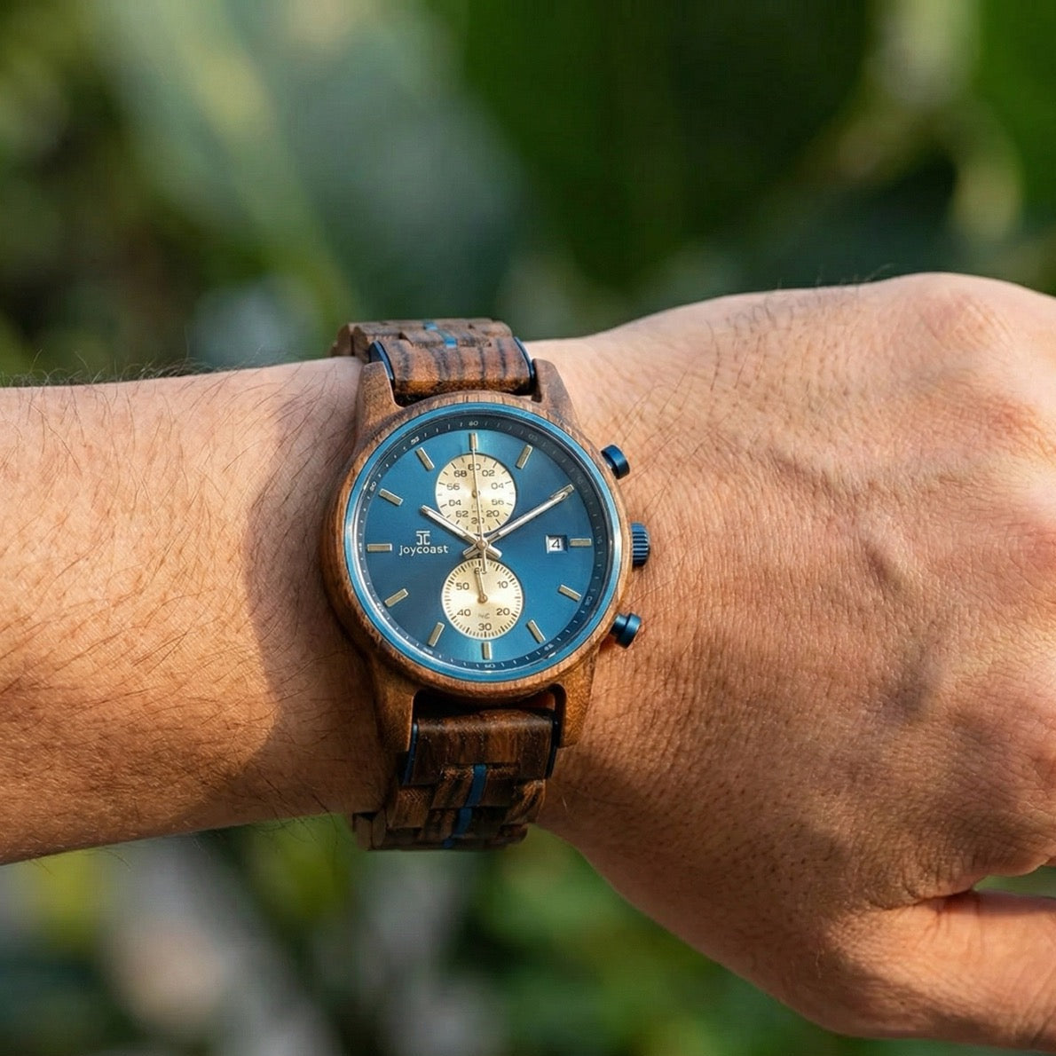 Wrist-worn zebrawood chronograph watch with blue face and brown striped wooden band