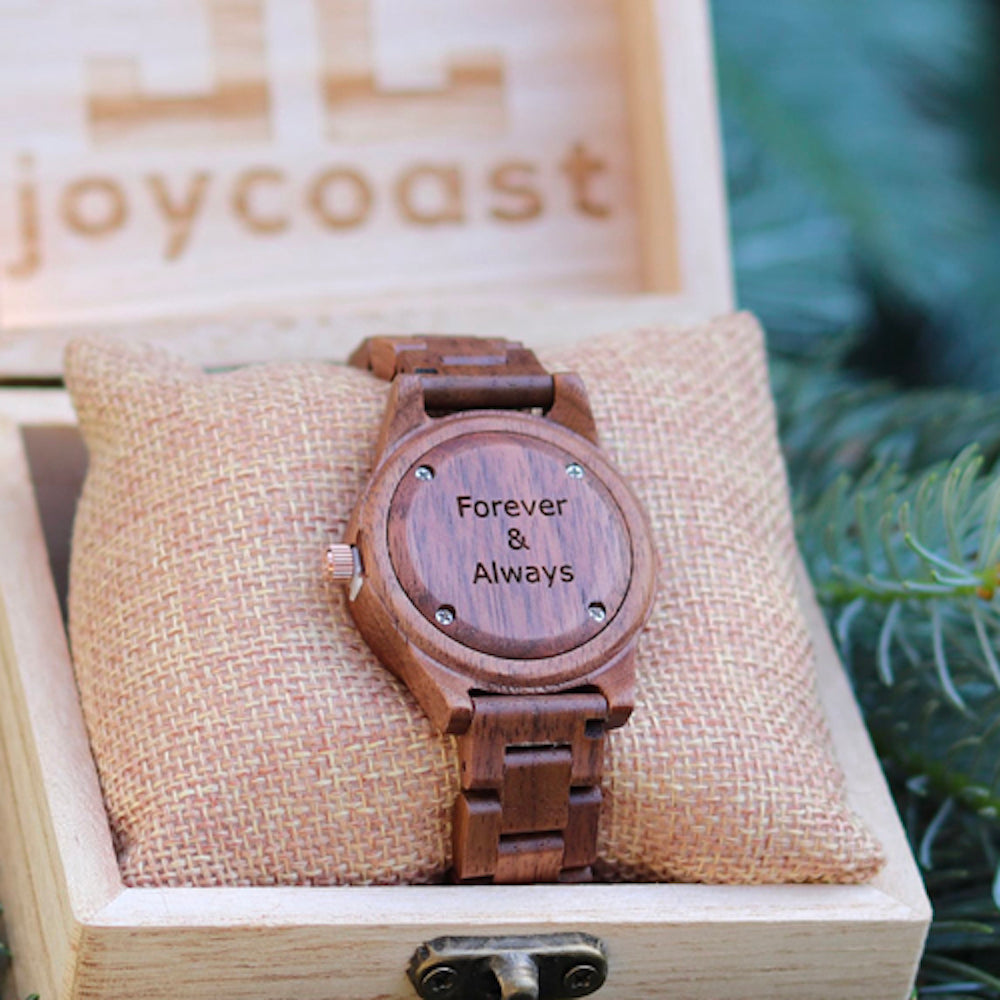 A Joycoast wooden watch displayed in a box, resting on a tree branch, showcasing its natural aesthetic and craftsmanship.