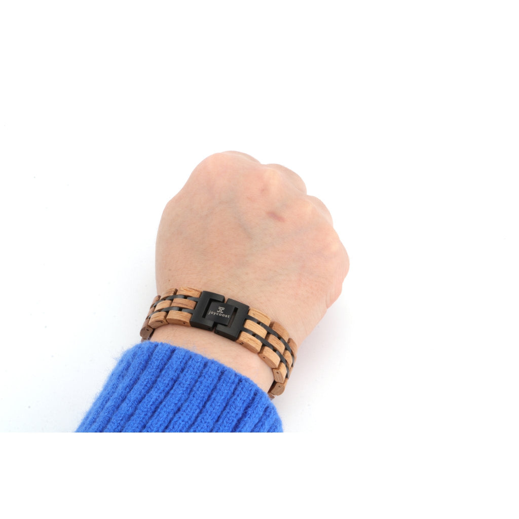 Men's wooden bracelet with black clasp, worn on wrist