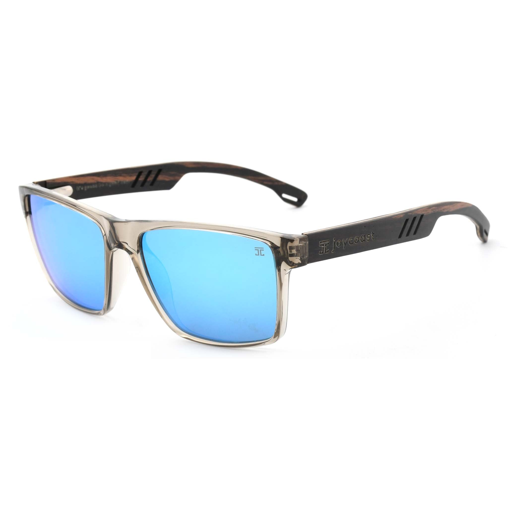 Joycoast Apex transparent frame sunglasses with blue reflective lenses and wooden arms, viewed from a side angle on a white background.
