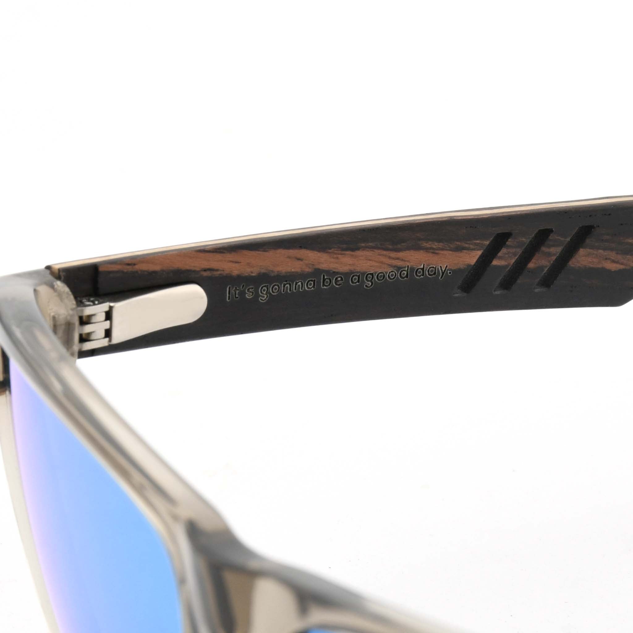 Close-up of a wooden sunglasses arm with visible vents and the "It's gonna be a good day." slogan engraved.