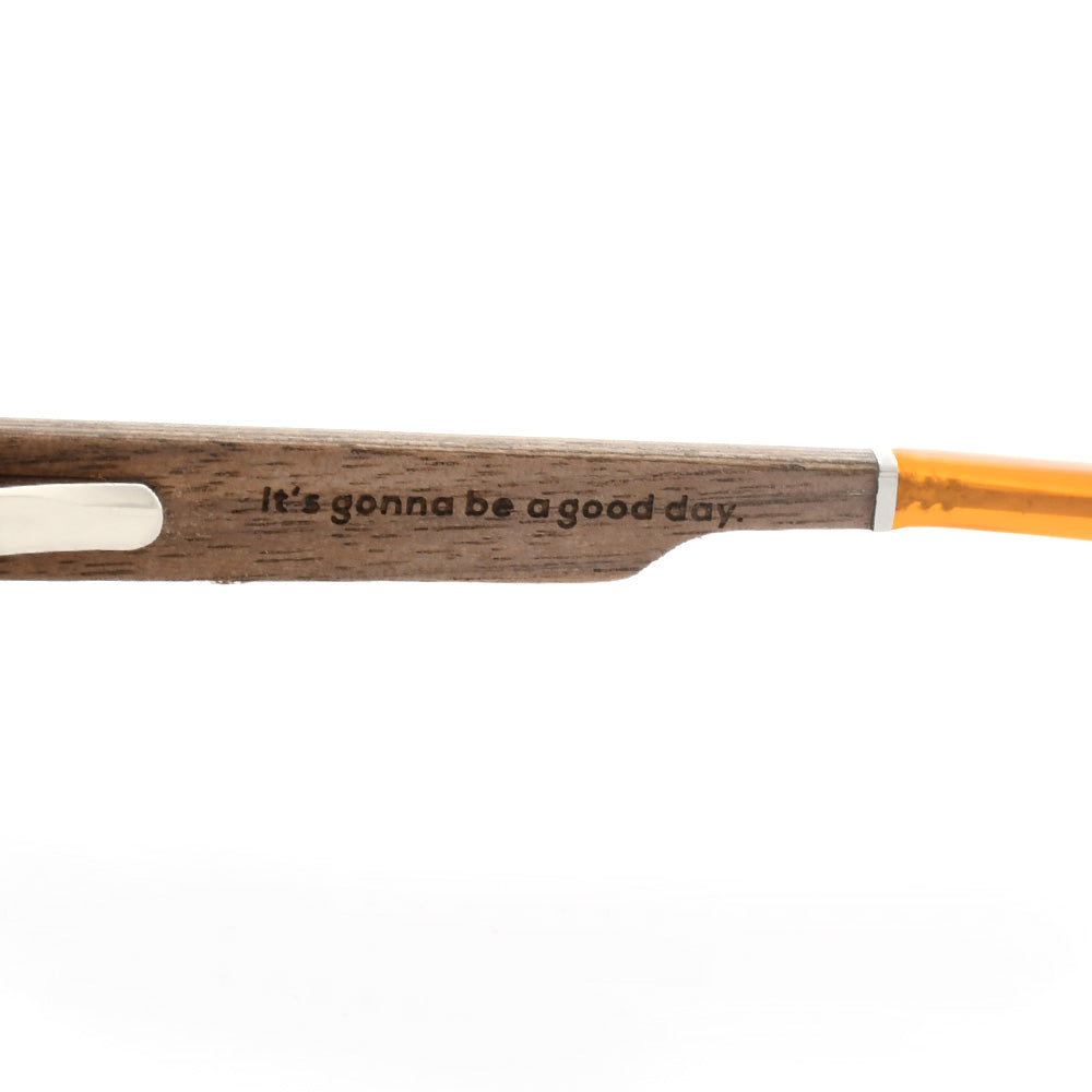 Wooden temple arm with engraved slogan on orange sunglasses