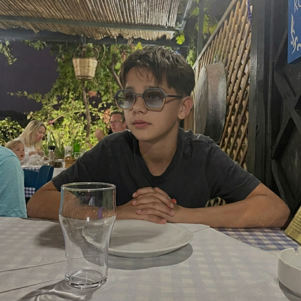 Kids’ black hexagon sunglasses with dark lenses, thin metal arms, worn by a child