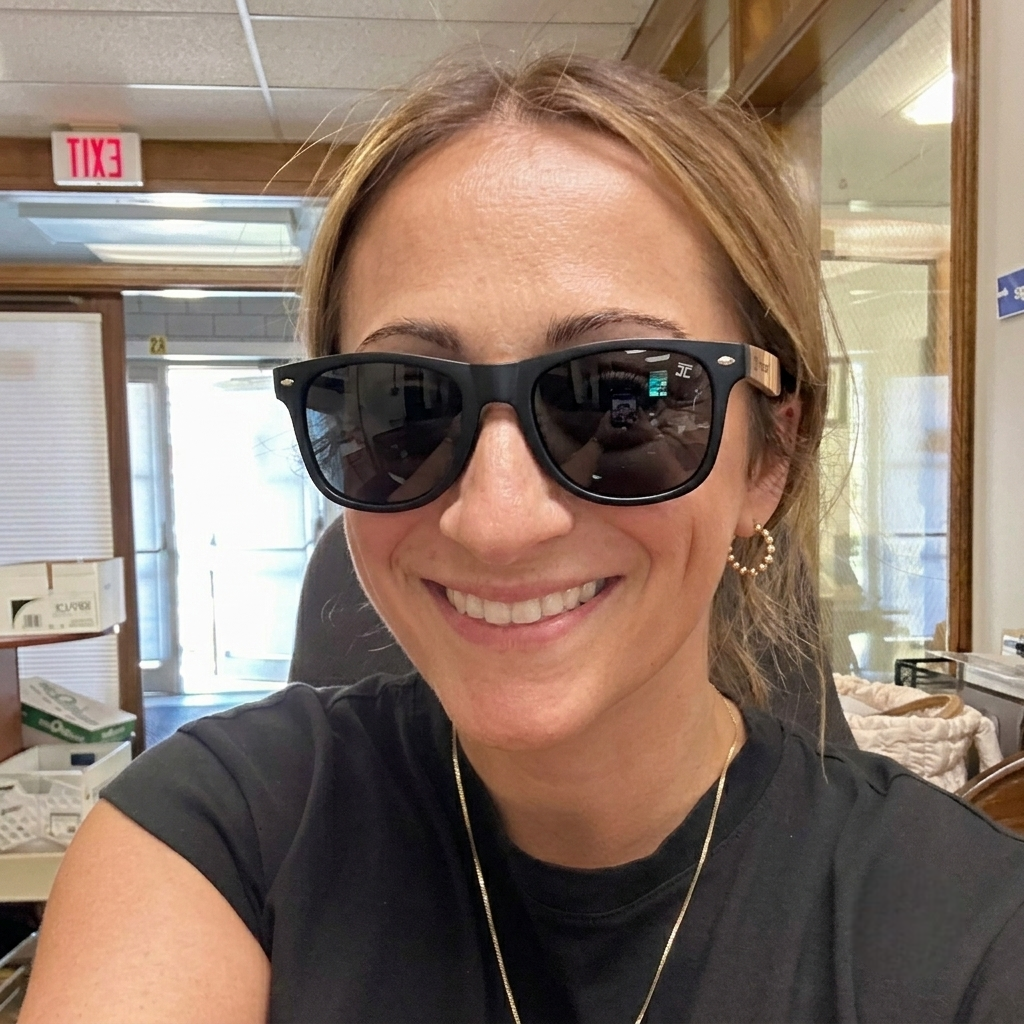 Wooden sunglasses worn on a person; black lenses and dark frame with wood temples
