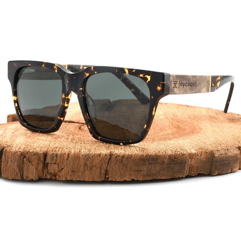 Dark tortoiseshell sunglasses with green lenses and wood-look temple arms