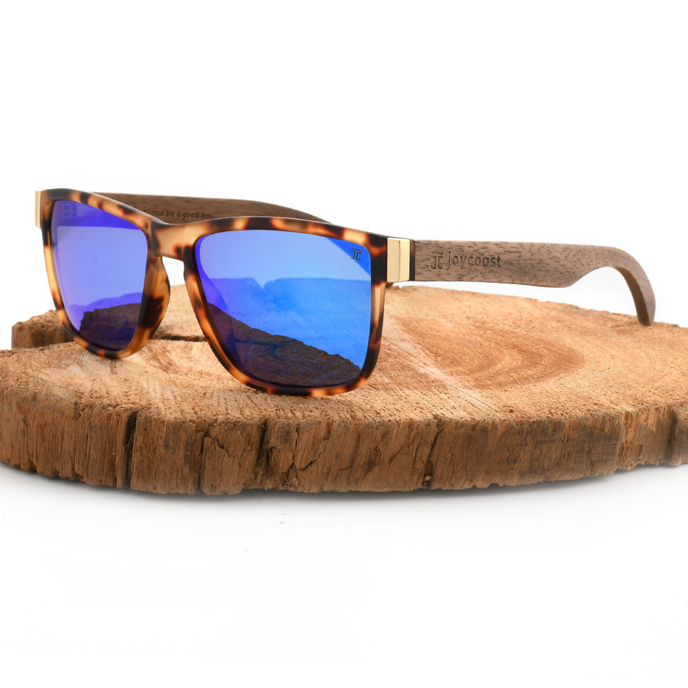 Tortoiseshell sunglasses with blue lenses and engraved joycoast wood arms