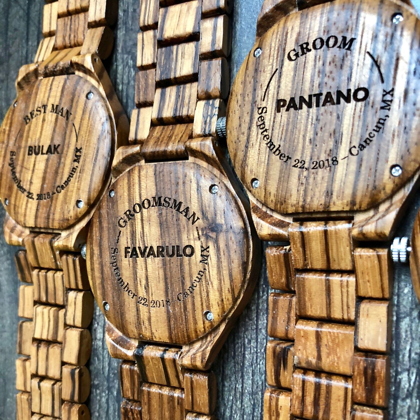 Custom wooden watches featuring unique engravings, showcasing craftsmanship and personalized design elements.