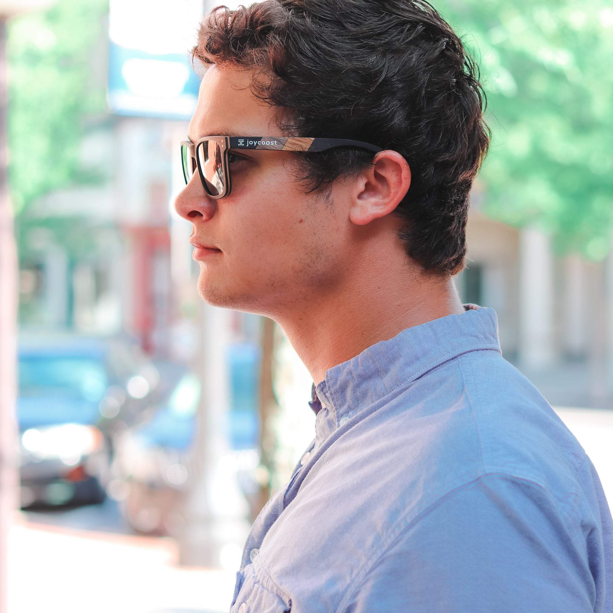 Sunglasses with dark lenses and zebrawood temples worn by man