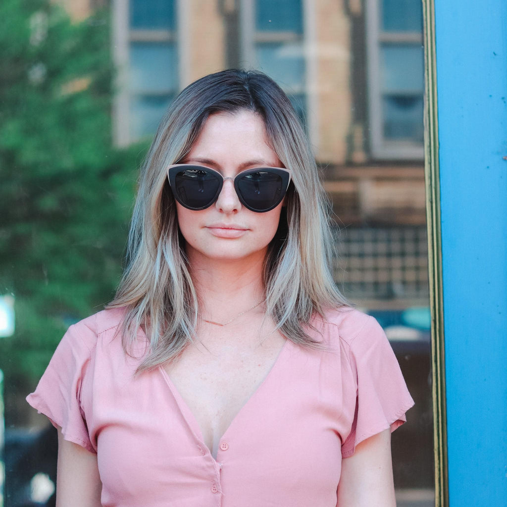Cat-eye sunglasses on woman, black frames with dark lenses