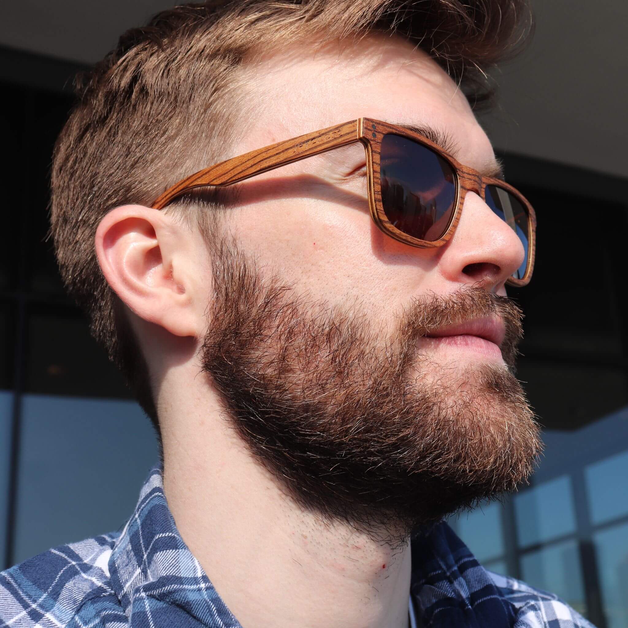 Wayfinder polarized sunglasses on a model, with dark lenses